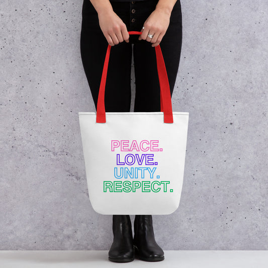 A woman wearing all black holding a white polyester tote bag with dual red handles and multicolored text that reads 'PEACE LOVE UNITY RESPECT.'