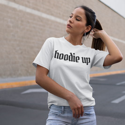 Woman wearing a white t-shirt with 'hoodie up' text in an outdoor setting.