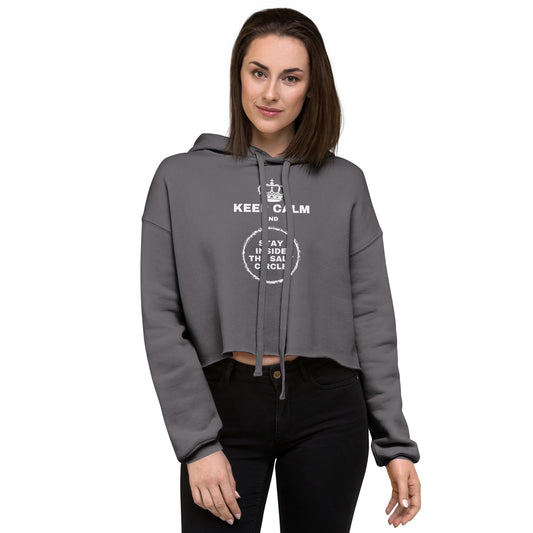 An athletic woman wearing a storm grey women's crop hoodie with a crown and underneath it text 'Keep Calm and Stay Inside the Salt Circle' printed on the front. Her pose demonstrates the length of the cropped waist.