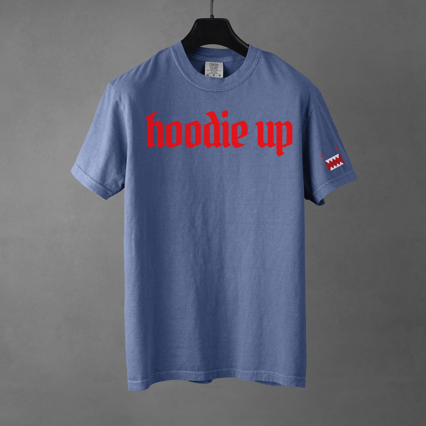 Blue t-shirt with red text 'hoodie up' on a gray background