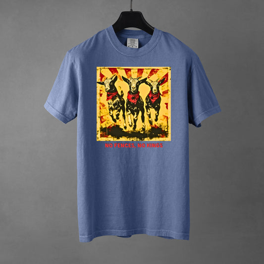 A blue jean colored Comfort Colors 1717 heavyweight t-shirt featuring a "No Fences, No Kings" graphic with three goats in red bandanas and a distressed sunburst background. Below the graphic is bold, red, all-caps text that reads, "NO FENCES, NO KINGS". The garment rests on a black hanger against a gradient gray background. 