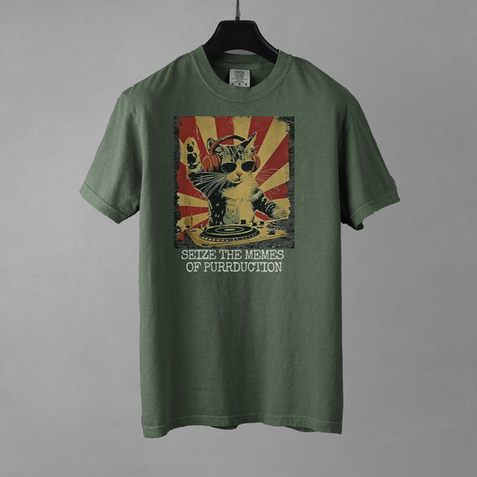 A moss green women's crew neck t-shirt with a graphic of a cat DJing against a vintage propaganda style poster background, with the text "SEIZE THE MEMES OF PURRDUCTION" at the bottom