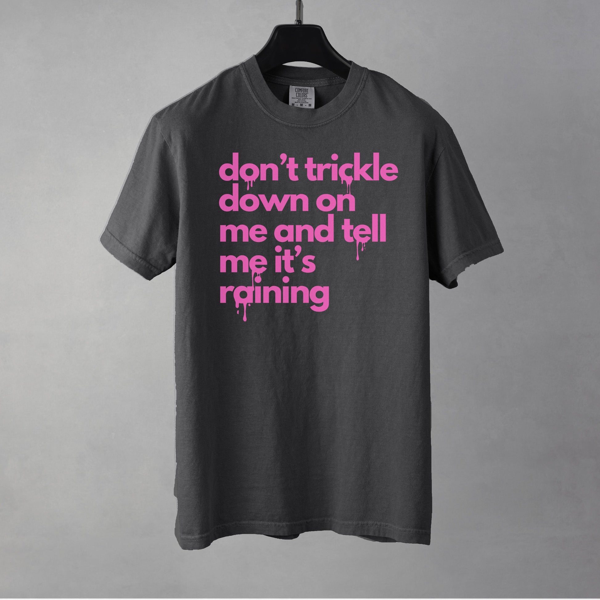 A pepper colored t-shirt with pink text on a gray background