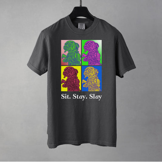 A pepper colored  men's t-shirt with a four-panel pop-art graphic of a feisty Chihuahua meme, with the text 'Sit. Stay. Slay' underneath as a tribute to the New Order album 'Technique' pop art style cover art.