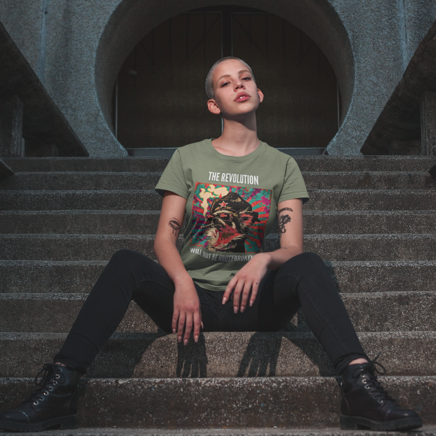 Person sitting on steps wearing a graphic t-shirt with text and images.