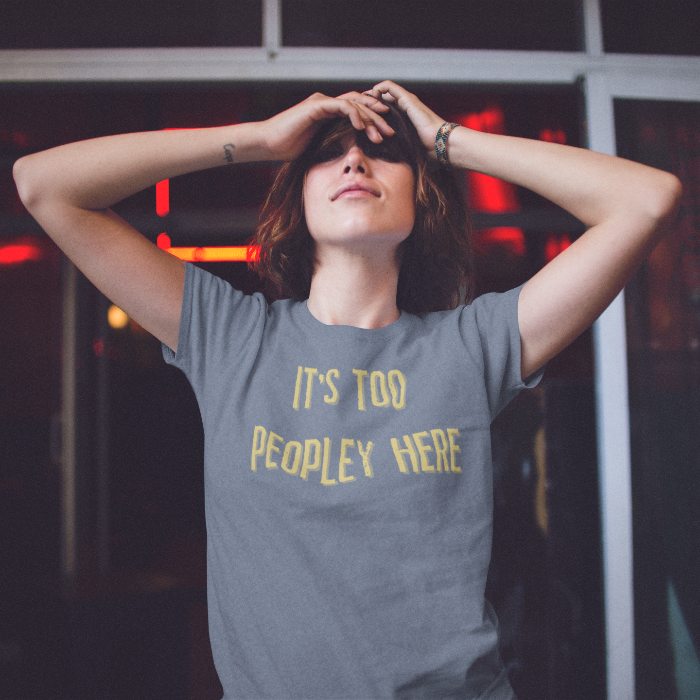 Person wearing a gray t-shirt with yellow text in an urban setting