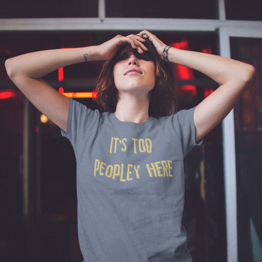 Person wearing a gray t-shirt with yellow text in an urban setting