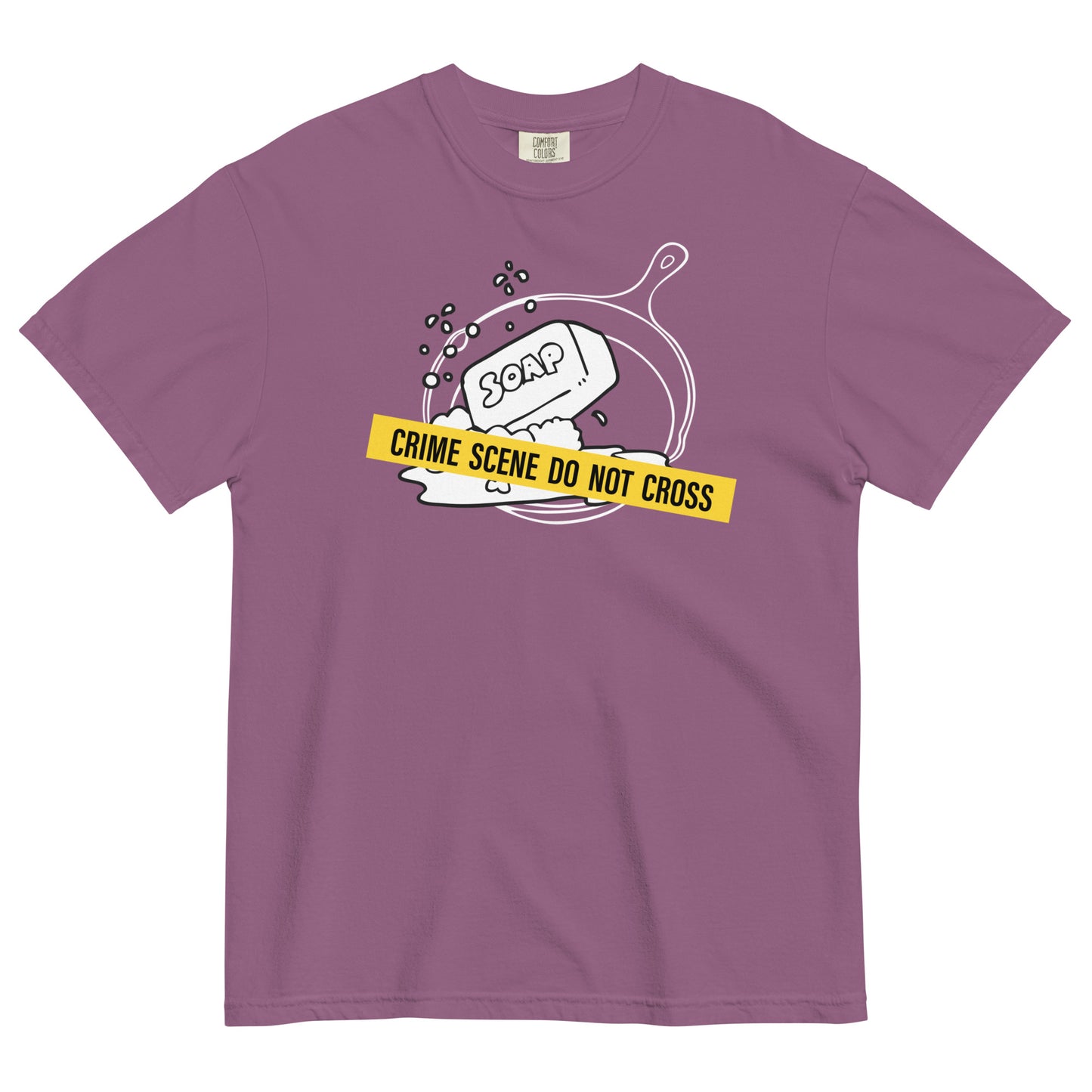 A berry colored t-shirt with a graphic of a cast iron pan with a bar of soap in it, crossed with crime scene tape that reads 'Crime Scene Do Not Cross'.