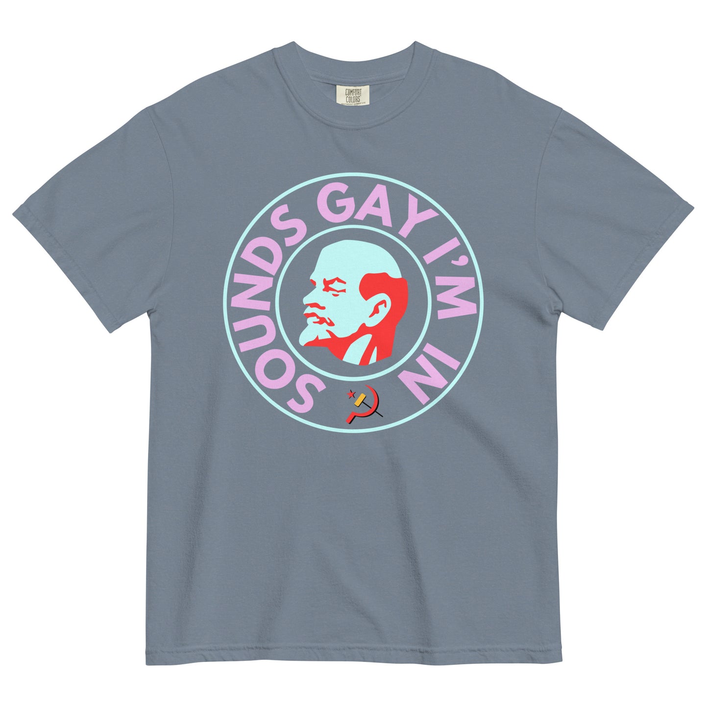 A blue jean colored crew neck t-shirt on a white background. The chest shows a graphic of an art deco style bust of Lenin's right profile with a light blue face and red hair, beard and eyebrows surrounded by a line circle in the same light blue. An outer circle of bold all caps neon pink text reads, 'SOUNDS GAY I'M IN' beginning at the 7 o'clock position. It is surrounded by the same light blue circle. 