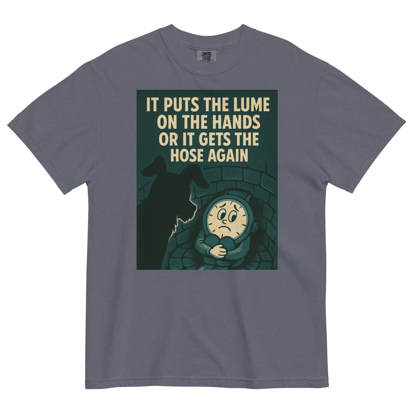 A denim colored t-shirt with a chest graphic in dark grayish green with a cream colored line drawing of an anamorphic watch face sitting at the bottom of a brick lined well with its knees drawn up to its chest, held by its arms. Looking down into the well is the silhouette of a small dog. The top of the graphic shows the text, in all caps, 'IT PUTS THE LUME ON THE HANDS OR IT GETS THE HOSE AGAIN'.