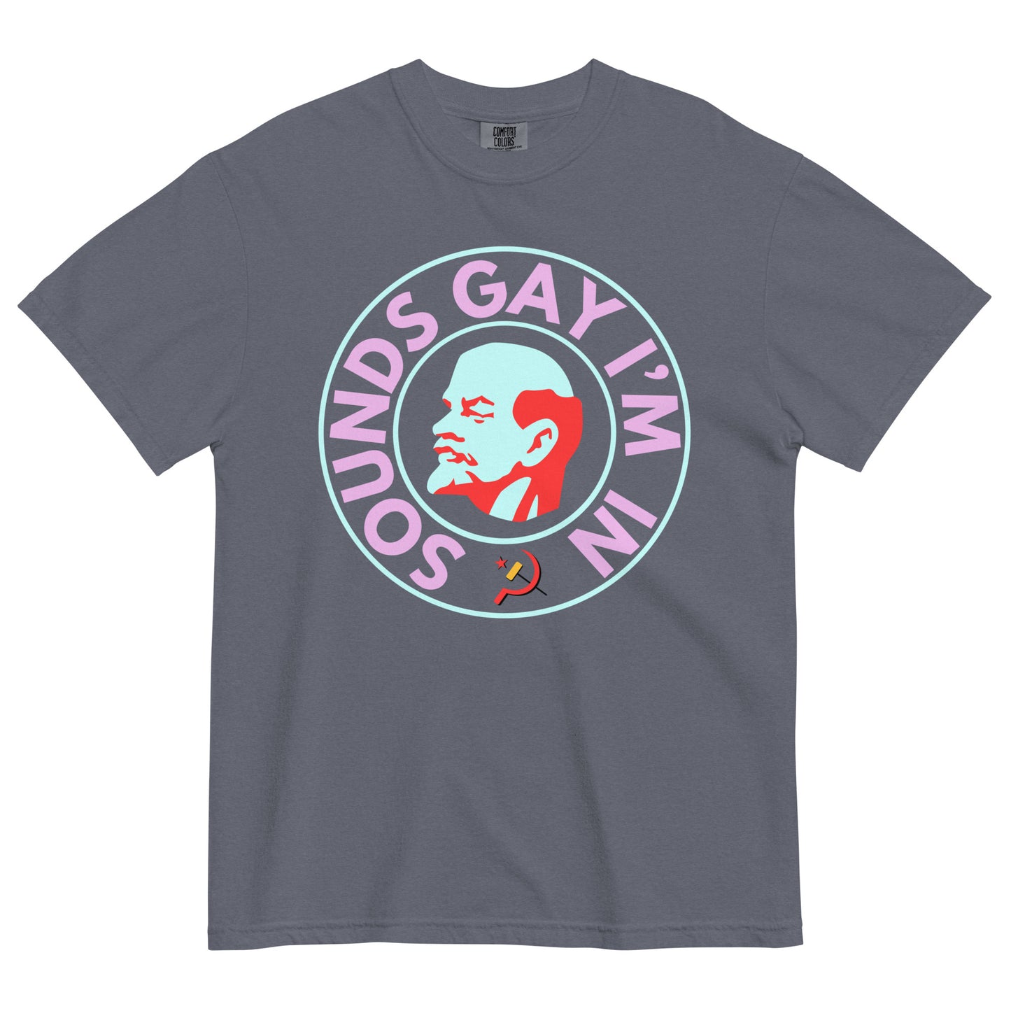 A denim colored crew neck t-shirt on a white background. The chest shows a graphic of an art deco style bust of Lenin's right profile with a light blue face and red hair, beard and eyebrows surrounded by a line circle in the same light blue. An outer circle of bold all caps neon pink text reads, 'SOUNDS GAY I'M IN' beginning at the 7 o'clock position. It is surrounded by the same light blue circle. 