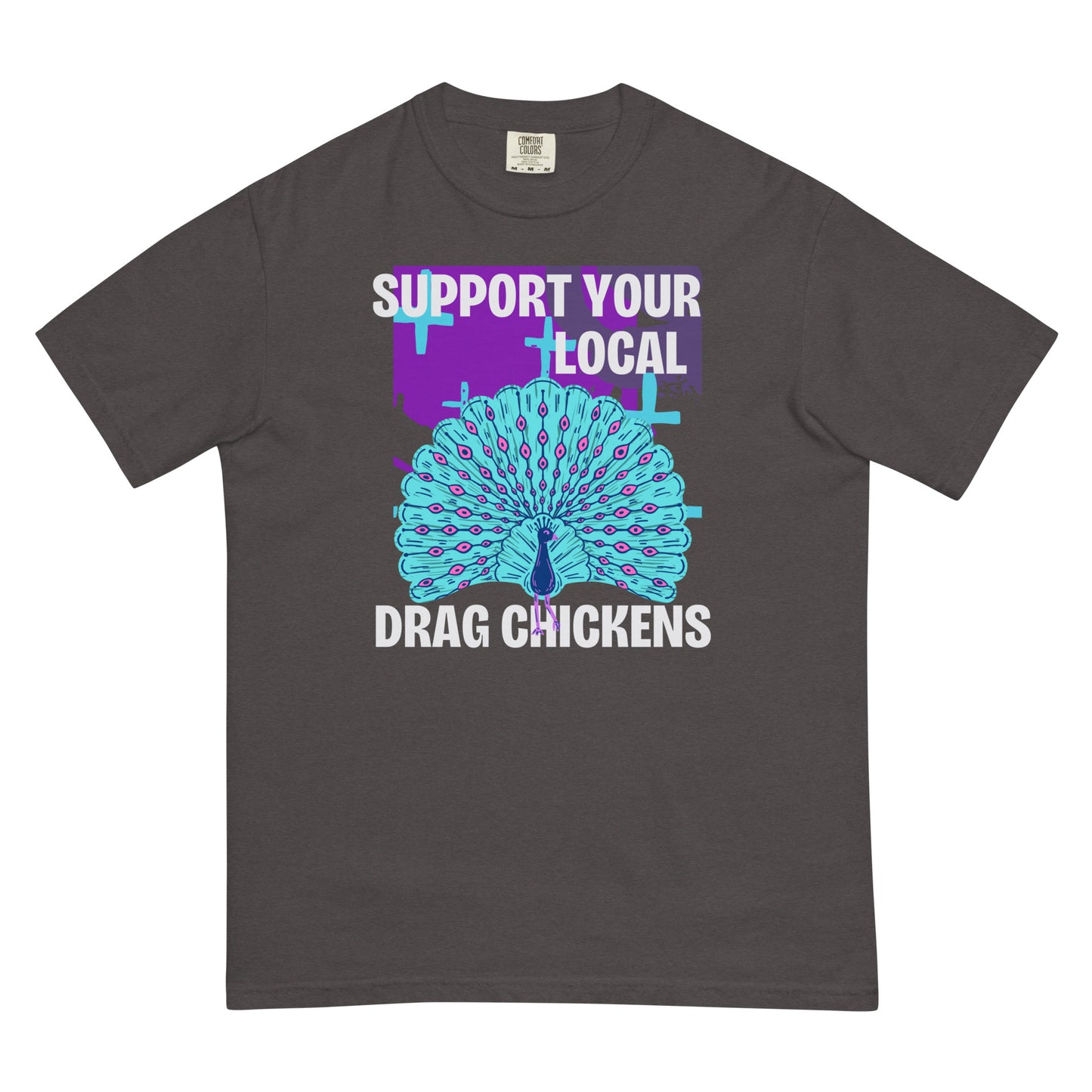 A graphite colored short-sleeve crewneck t-shirt featuring a stylized graphic of a peacock with its tail feathers fully fanned out. The peacock is light blue with pink eye details, set against a distressed purple background block with light blue plus signs. Above the peacock is bold white text reading 'SUPPORT YOUR LOCAL', and below it reads 'DRAG CHICKENS'.