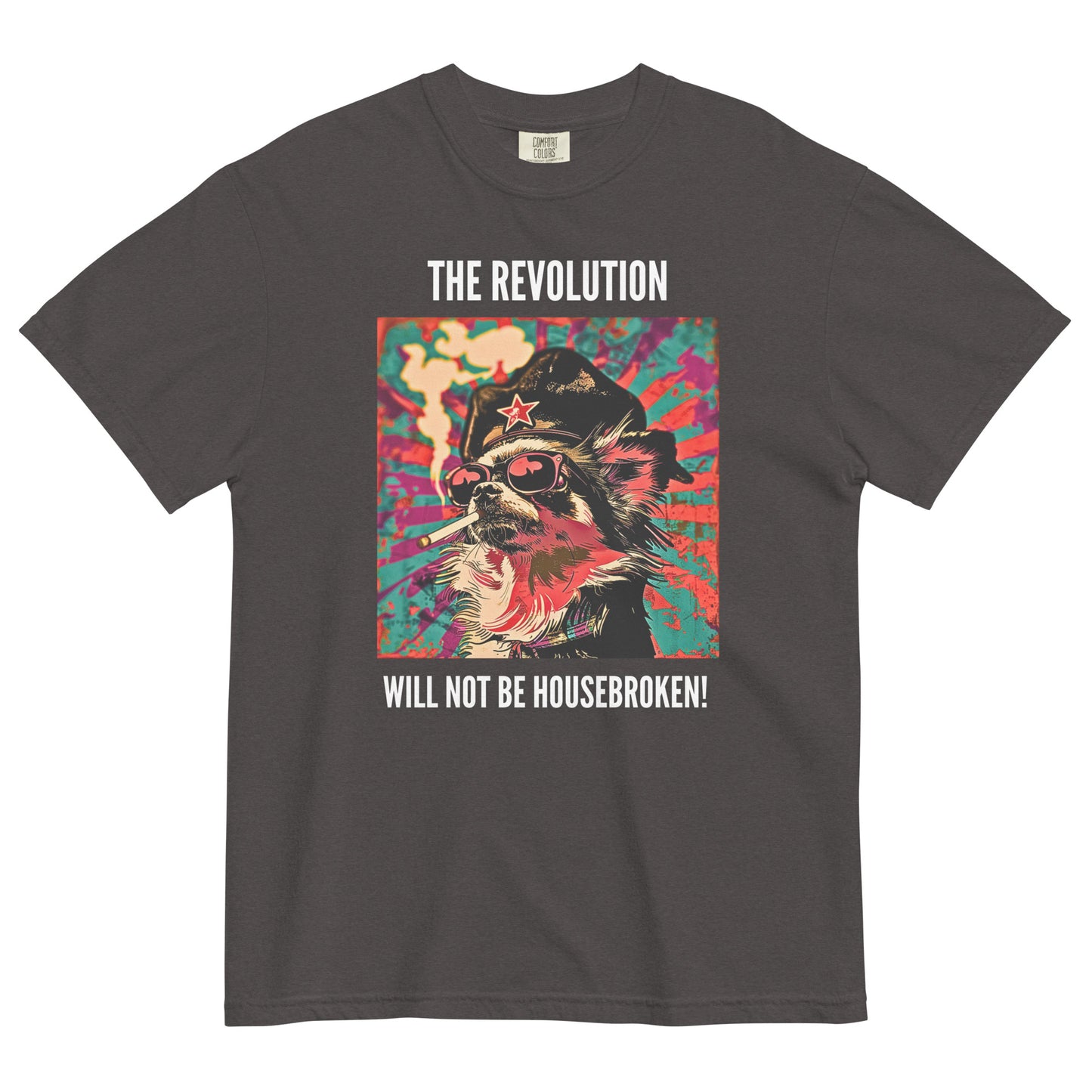 A graphite colored short-sleeve crewneck t-shirt featuring a vibrant, pop-art style square graphic on the chest. The illustration shows a long-haired Chihuahua stylized as a revolutionary, wearing a black hat with a red star, red-tinted sunglasses, and smoking a cigarette, set against a colorful, grunge-textured teal and red sunburst background. Above the graphic in white capital letters is the text 'THE REVOLUTION', and below it reads 'WILL NOT BE HOUSEBROKEN!'.