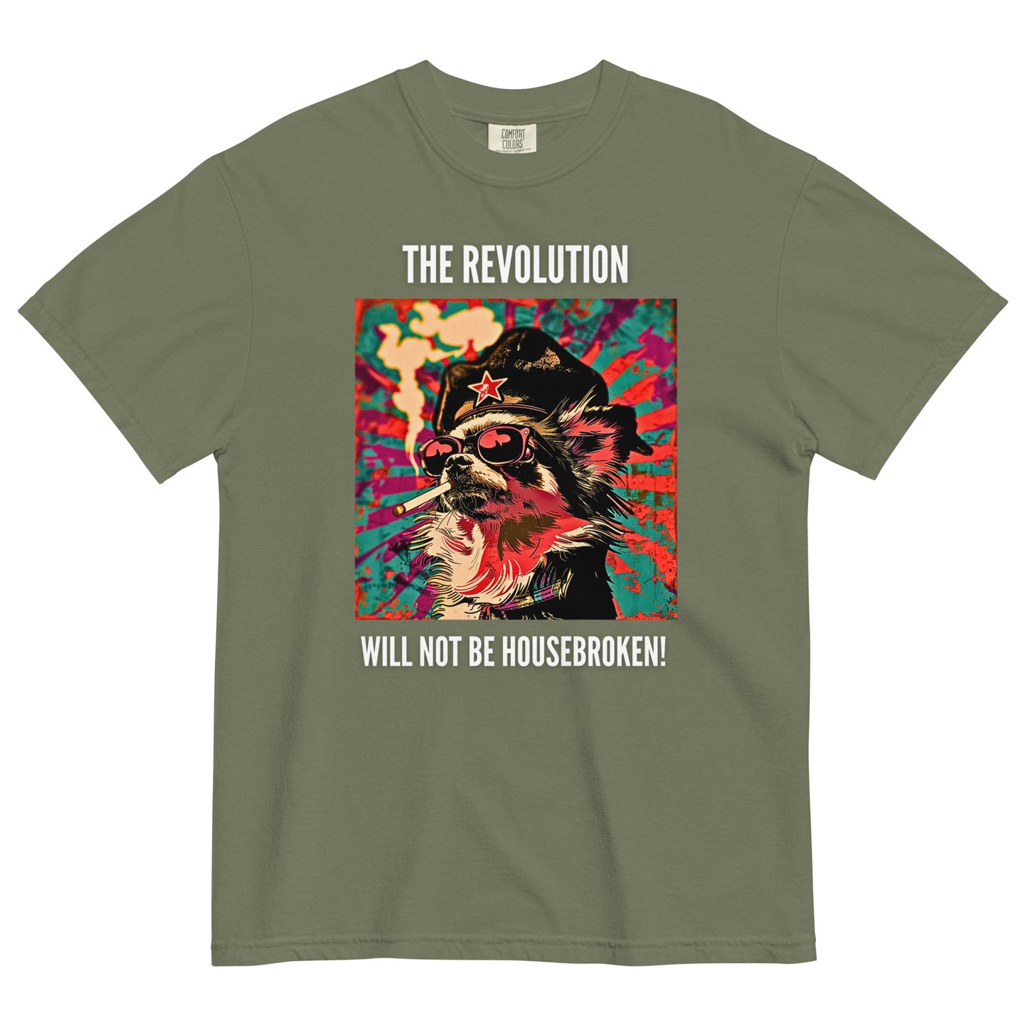 A moss green colored short-sleeve crewneck t-shirt featuring a vibrant, pop-art style square graphic on the chest. The illustration shows a long-haired Chihuahua stylized as a revolutionary, wearing a black hat with a red star, red-tinted sunglasses, and smoking a cigarette, set against a colorful, grunge-textured teal and red sunburst background. Above the graphic in white capital letters is the text 'THE REVOLUTION', and below it reads 'WILL NOT BE HOUSEBROKEN!'.