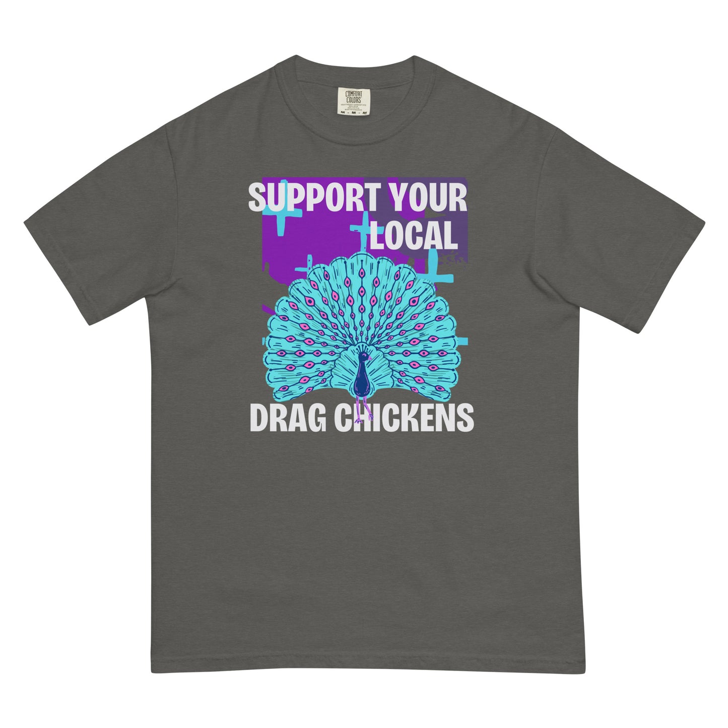 A pepper colored short-sleeve crewneck t-shirt featuring a stylized graphic of a peacock with its tail feathers fully fanned out. The peacock is light blue with pink eye details, set against a distressed purple background block with light blue plus signs. Above the peacock is bold white text reading 'SUPPORT YOUR LOCAL', and below it reads 'DRAG CHICKENS'.