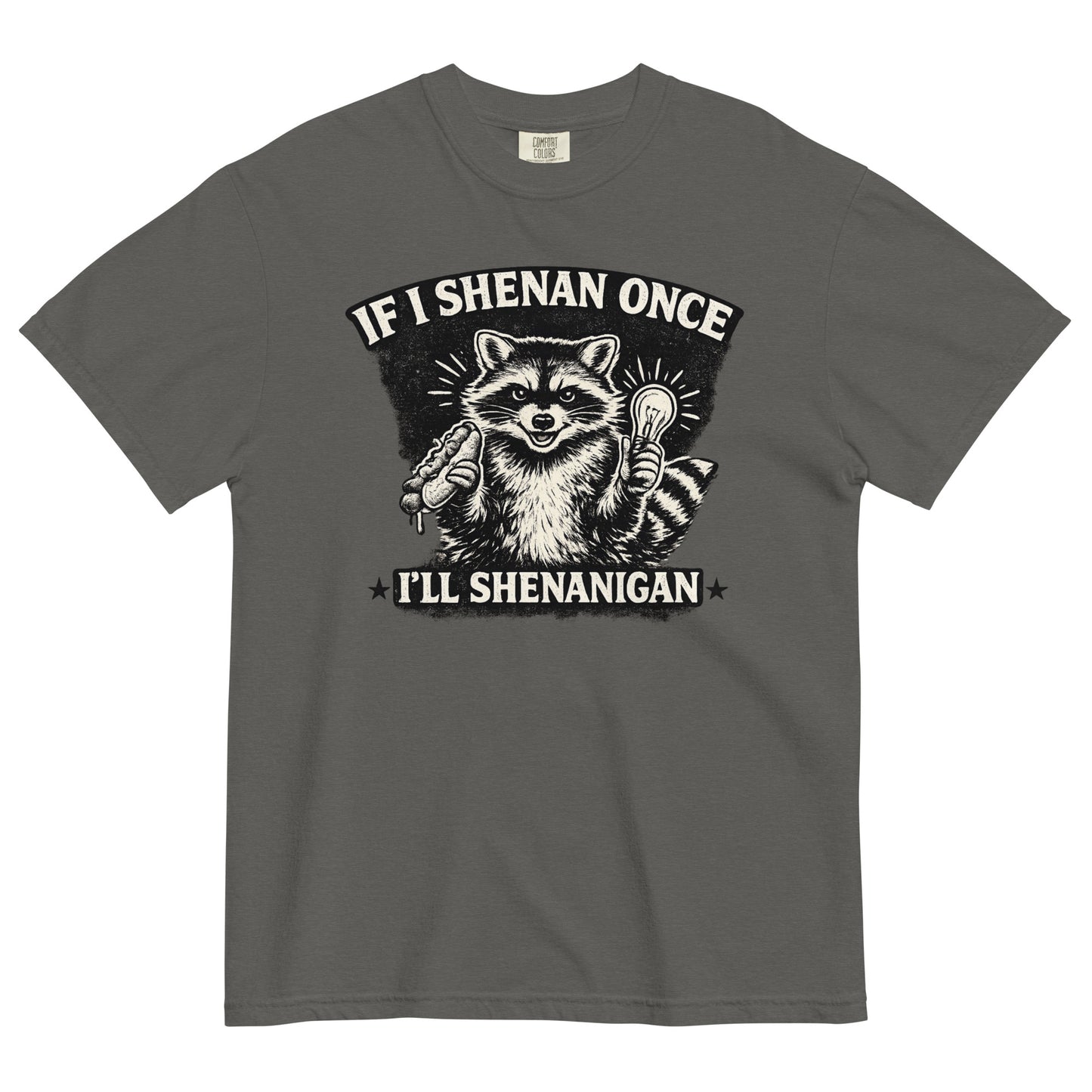 A pepper colored short-sleeve crewneck t-shirt featuring a distressed black and white illustration of a smiling raccoon holding a hot dog in one paw and a glowing lightbulb in the other. Arched above the raccoon is text that reads 'IF I SHENAN ONCE', and below the raccoon is text flanked by stars that reads 'I'LL SHENANIGAN'.