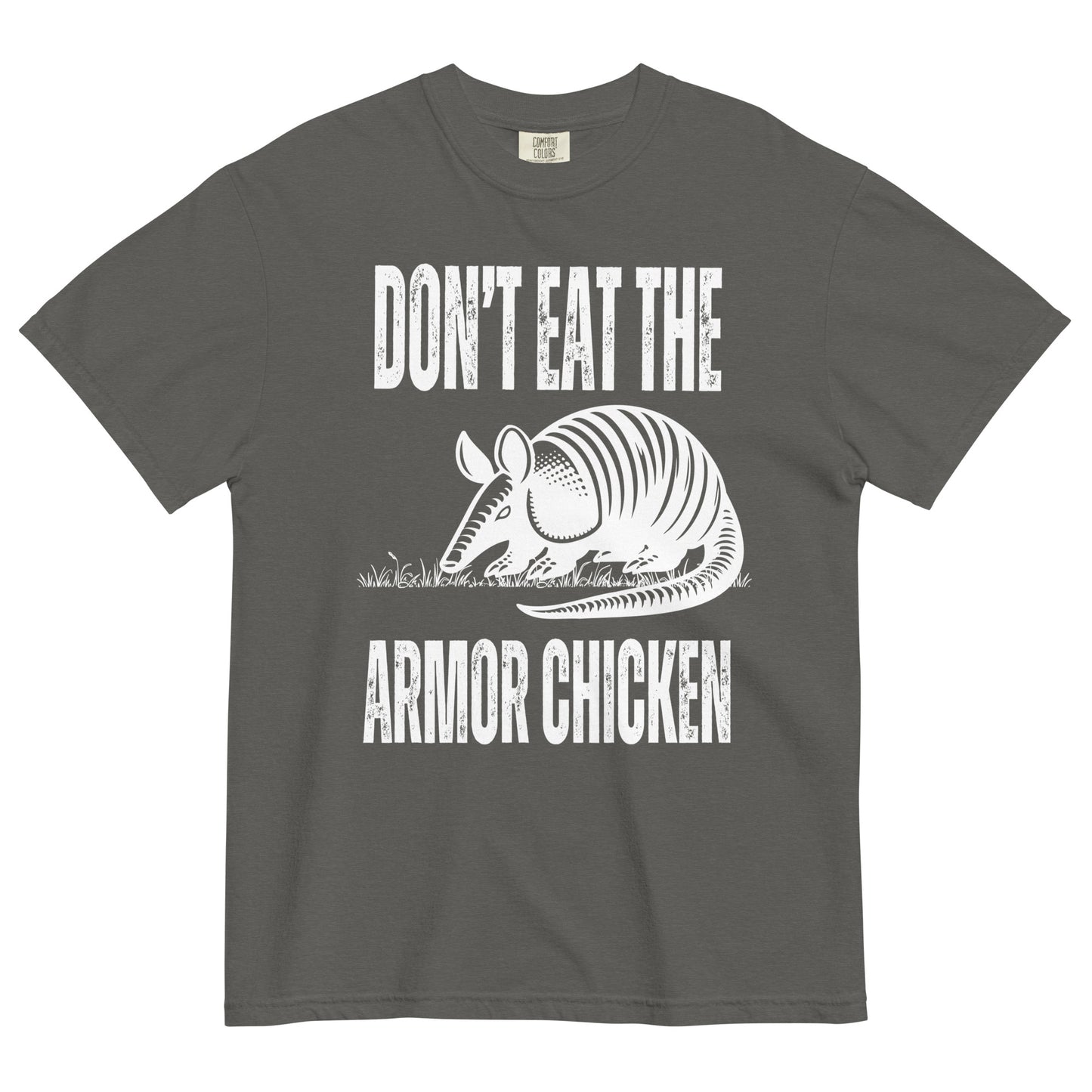 A pepper colored t-shirt with bold, all-caps, distressed white text that says 'DONT EAT THE ARMOR CHICKEN'. The text is separated into two lines by a white, line drawing graphic of an armadillo eating grass. 