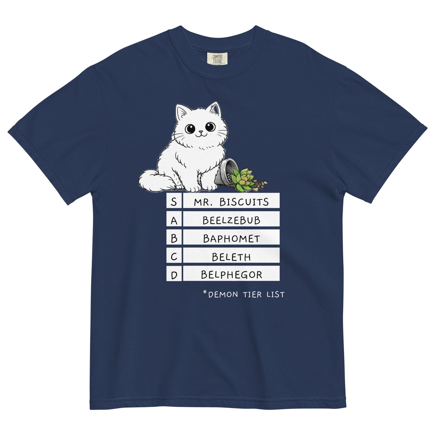 A true navy colored t-shirt with a graphic of a white, fluffy kitten standing behind a knocked over plant. Beneath the cat is a 'Demon Tier List' with the cat 'Mr. Biscuits' listed atop the list in the S tier position.