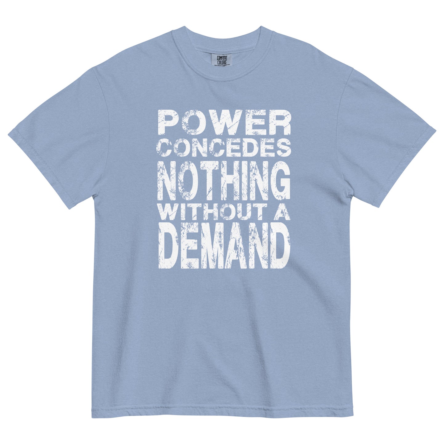 A washed denim colored women's heavyweight t-shirt featuring a bold white graphic centered on the chest. The text is arranged in 5 stacked lines and reads "POWER CONCEDES NOTHING WITHOUT A DEMAND" in an all-caps. The lettering is white and features a heavily distressed and weathered texture.