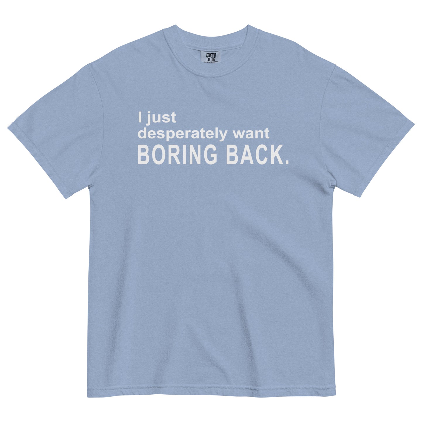 A washed denim colored graphic t-shirt with the words "I just desperately want BORING BACK." printed in bold white sans-serif text across the chest.