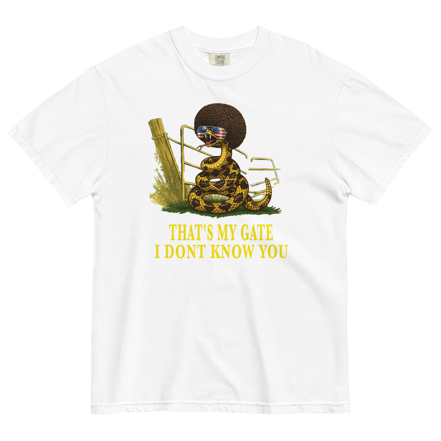 A white colored graphic t-shirt featuring a coiled rattlesnake, in front of a broken gate, with a large brown afro and flag-mirrored sunglasses above yellow text that reads "THAT'S MY GATE I DONT KNOW YOU."